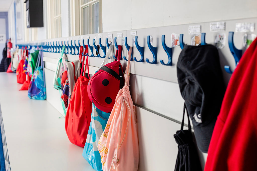 Werken aan inclusie door WegWijs in Gedrag; foto van een kapstok in een schoolgang